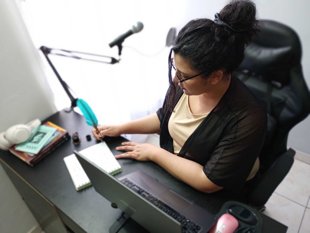 Carylis Palacios Writing A Draft By Hand From Her Desk